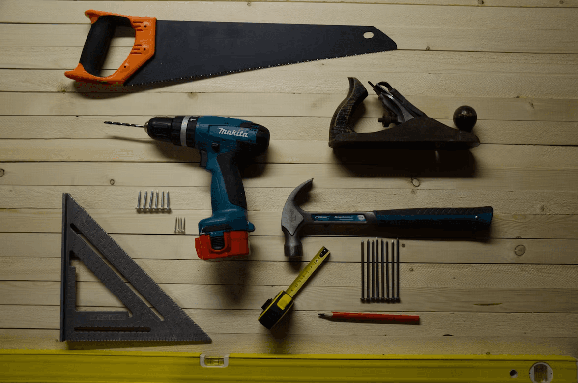 Assorted power tools and hand tools laid out on a workbench