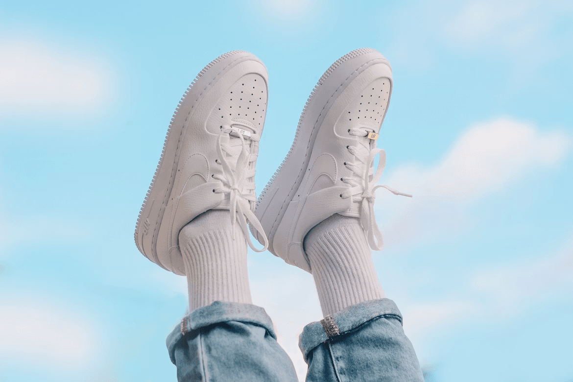 A pair of white Nike sneakers against a blue sky