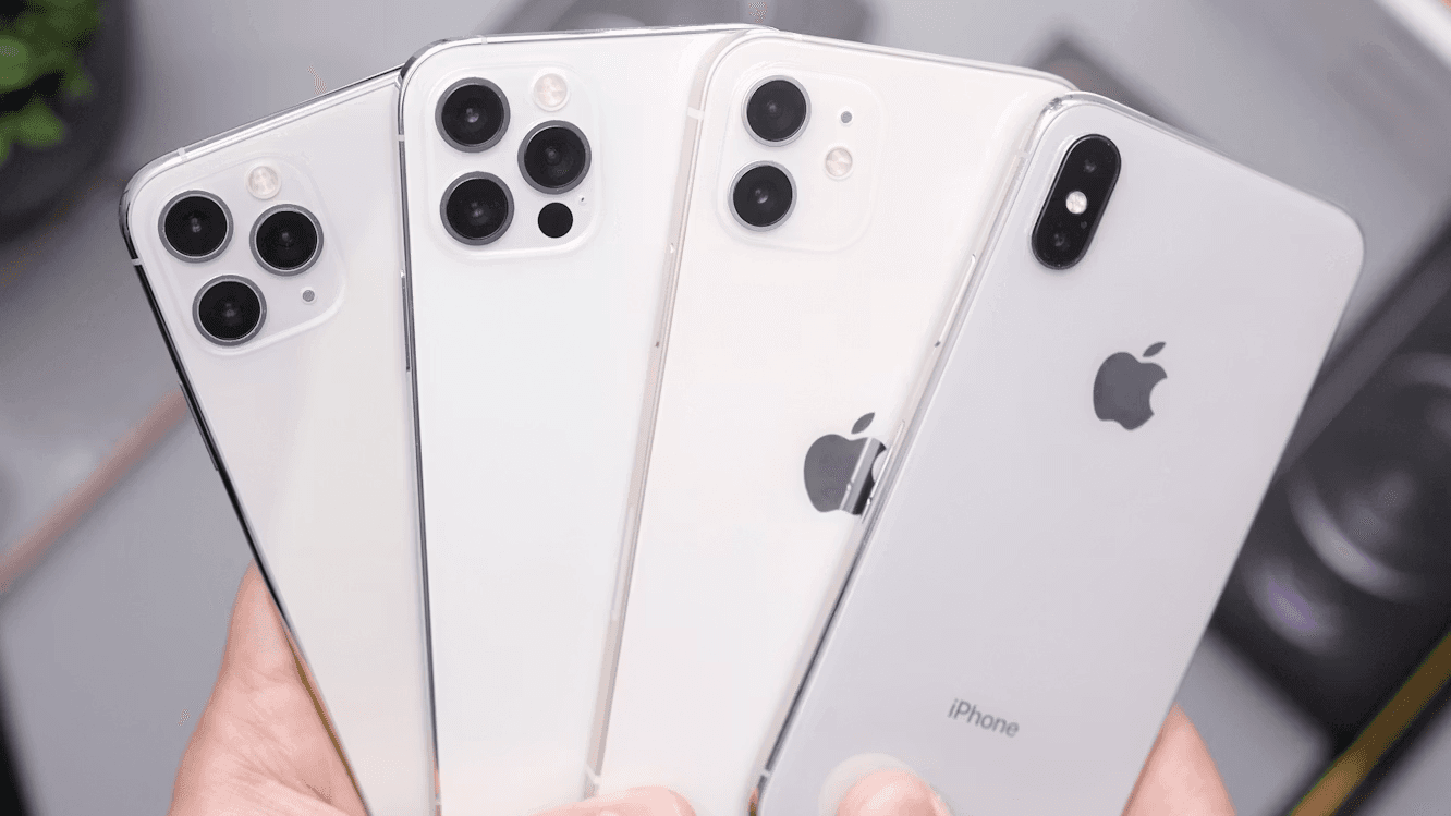 Four used iPhones held in a person’s hands